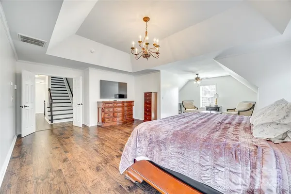 a spacious bedroom with a bed dresser and a window