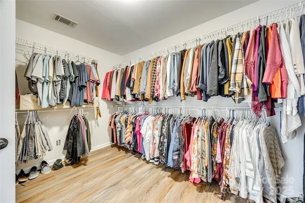 a view of walk in closet with clothes
