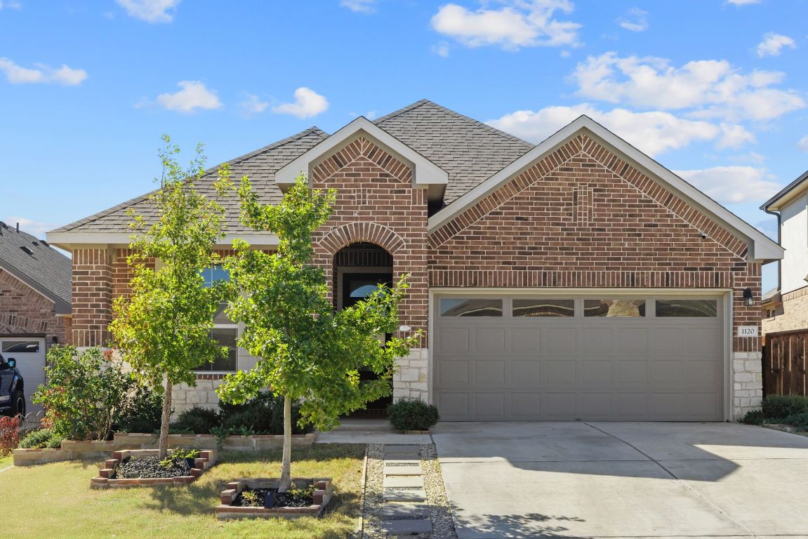 1120 Bear Track Loop Georgetown, TX 78628 - Photo 1 of 26 View of front of home with brick siding, driveway, an attached garage, roof with shingles, and stone siding