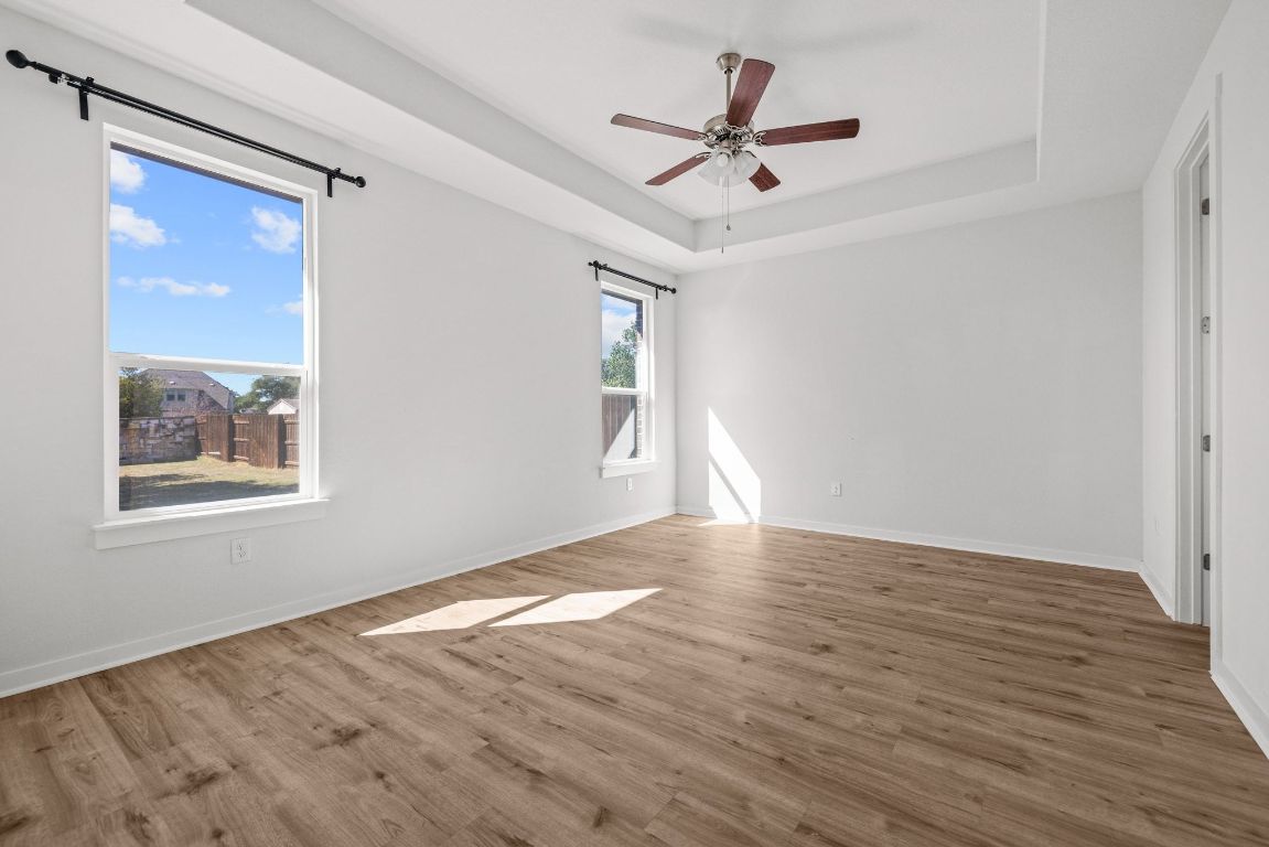 1120 Bear Track Loop Georgetown, TX 78628 - Photo 11 of 26 Spare room with wood finished floors, a raised ceiling, and ceiling fan
