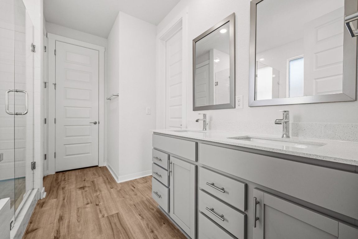 1120 Bear Track Loop Georgetown, TX 78628 - Photo 13 of 26 Full bath with double vanity, light wood finished floors, and a shower stall