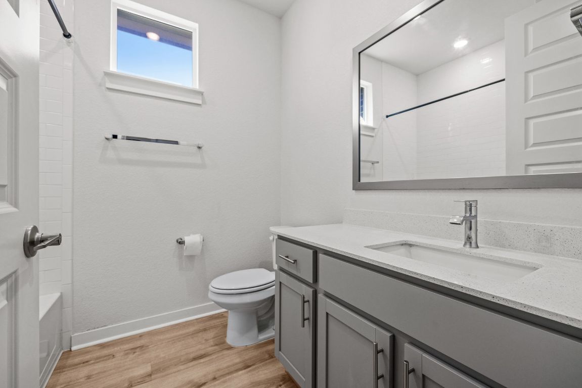 1120 Bear Track Loop Georgetown, TX 78628 - Photo 18 of 26 Bathroom with healthy amount of natural light, vanity, light wood-style floors, and tub / shower combination