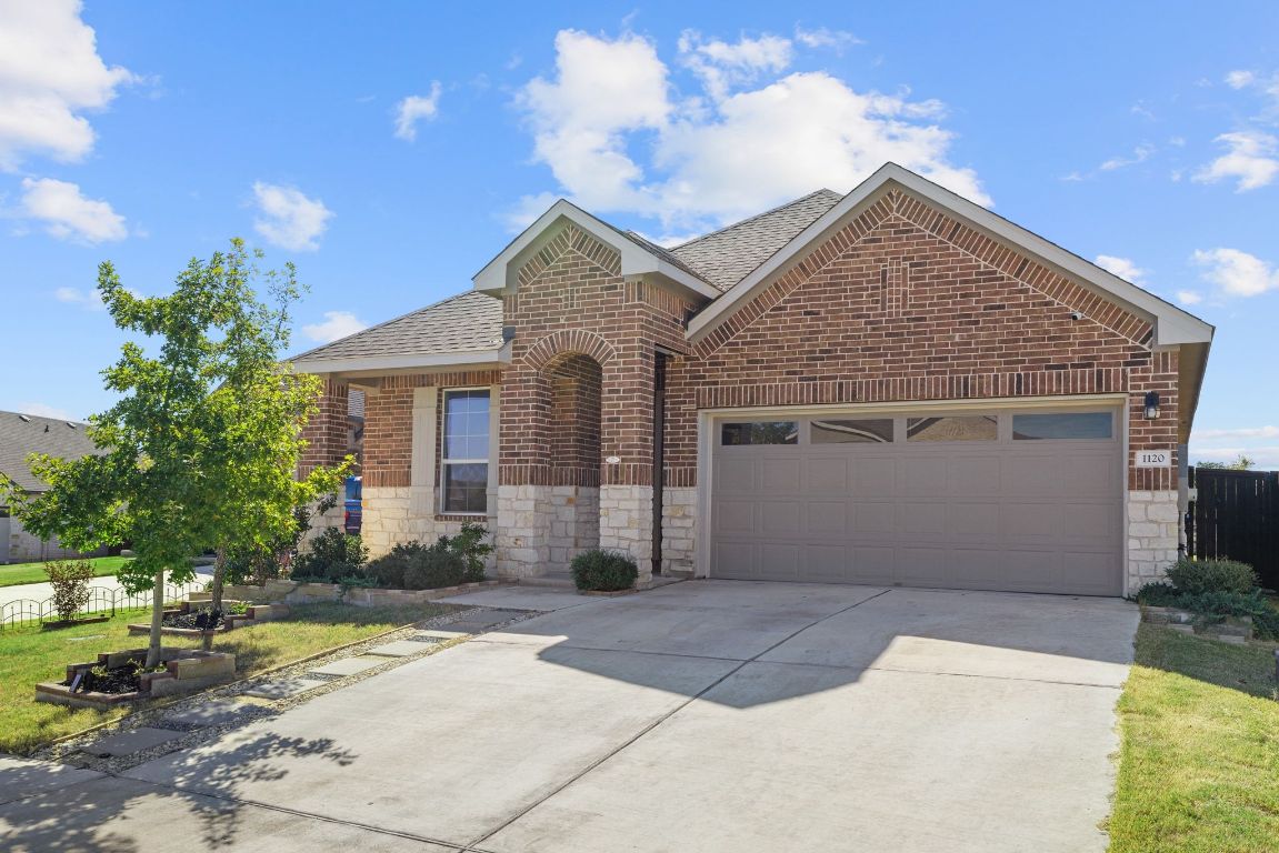 1120 Bear Track Loop Georgetown, TX 78628 - Photo 2 of 26 View of front of house with roof with shingles, brick siding, driveway, a garage, and stone siding