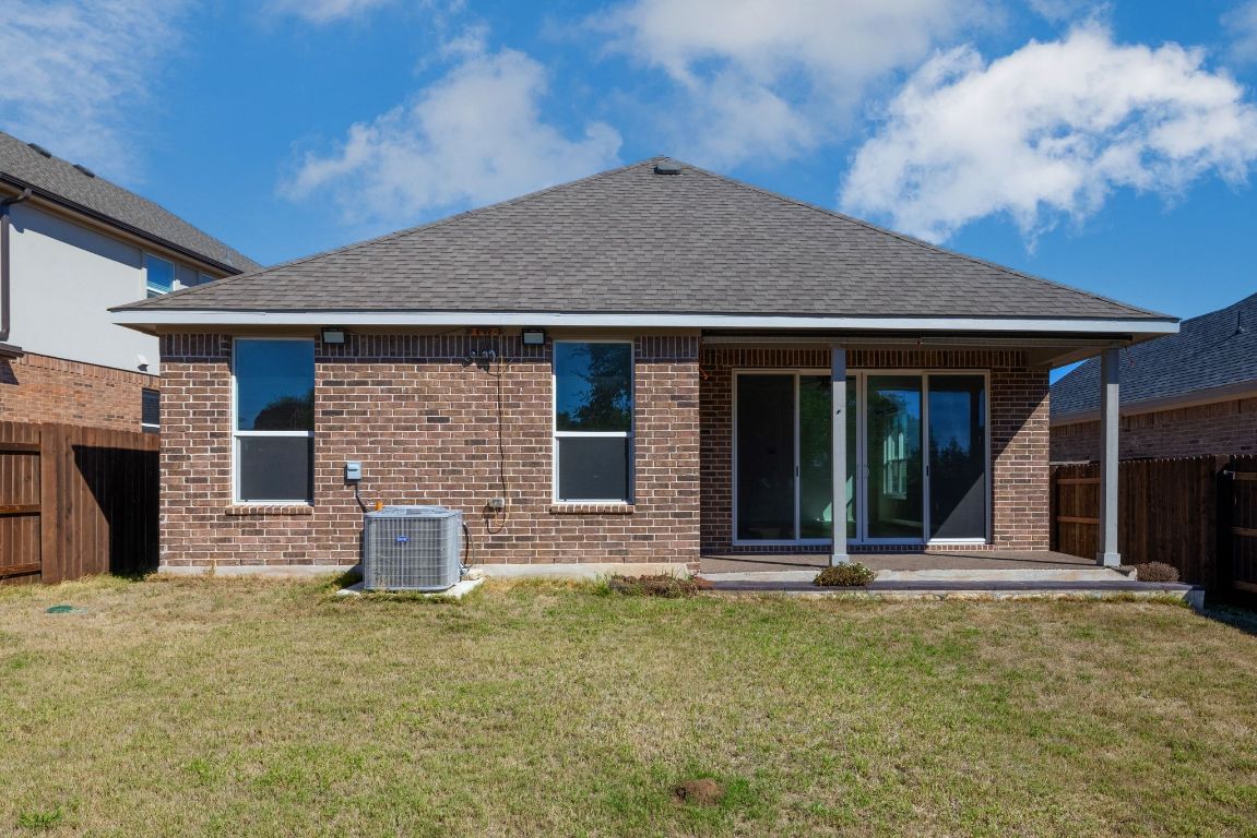 1120 Bear Track Loop Georgetown, TX 78628 - Photo 23 of 26 Back of house featuring a fenced backyard, brick siding, a patio area, and a shingled roof