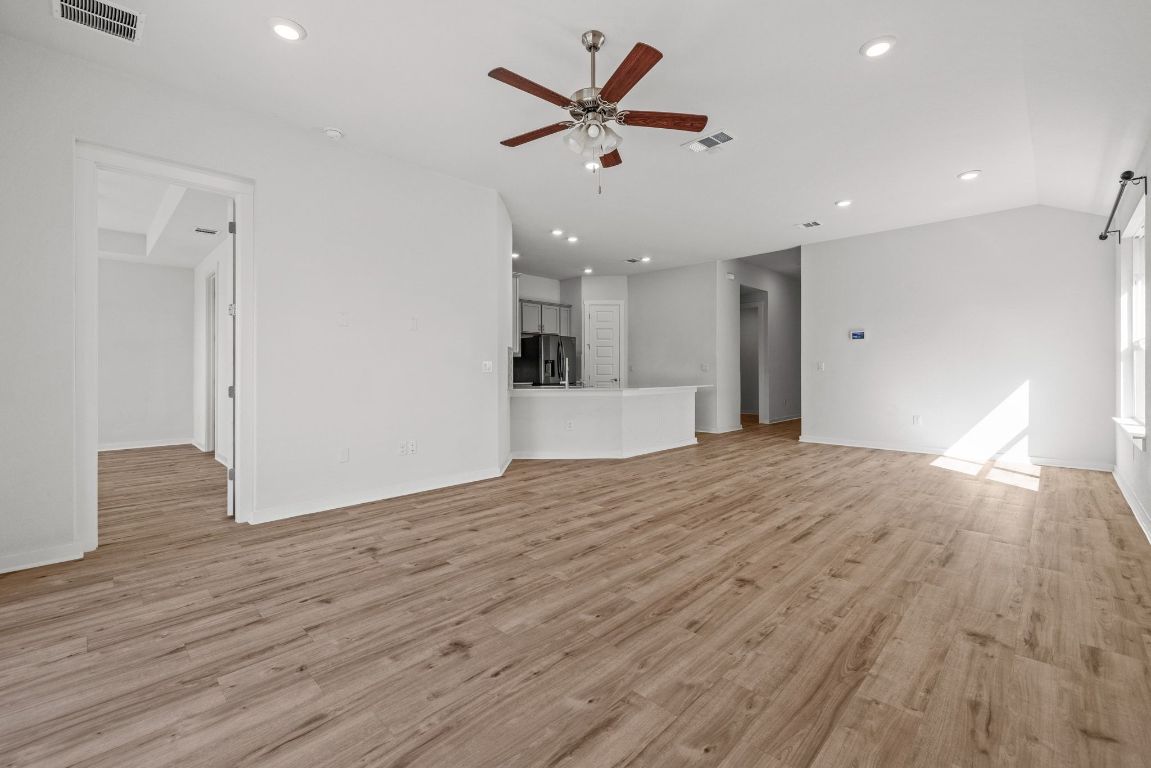 1120 Bear Track Loop Georgetown, TX 78628 - Photo 4 of 26 Unfurnished living room featuring light wood finished floors, a ceiling fan, recessed lighting, and vaulted ceiling