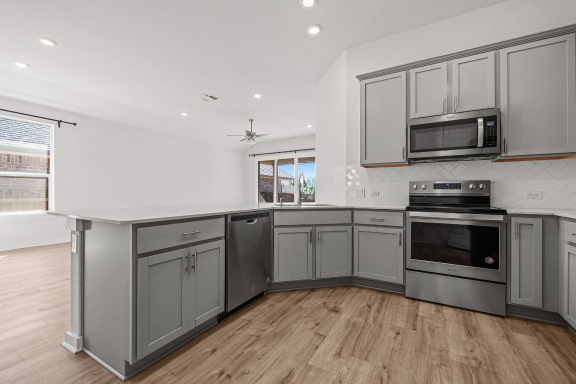 1120 Bear Track Loop Georgetown, TX 78628 - Photo 8 of 26 Kitchen with gray cabinetry, stainless steel appliances, recessed lighting, decorative backsplash, and a peninsula