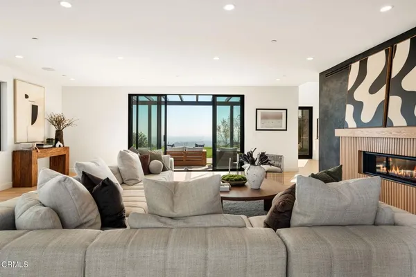 a living room with furniture fireplace and a large window