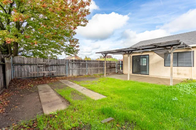 a view of a backyard with a garden and tree
