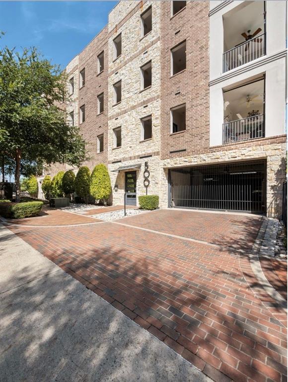 5001 Meridian Lane, Unit 2103 Addison, TX 75001 - Photo 1 of 26 Brick paver driveway leading to a multi-story building featuring stone and brick facade