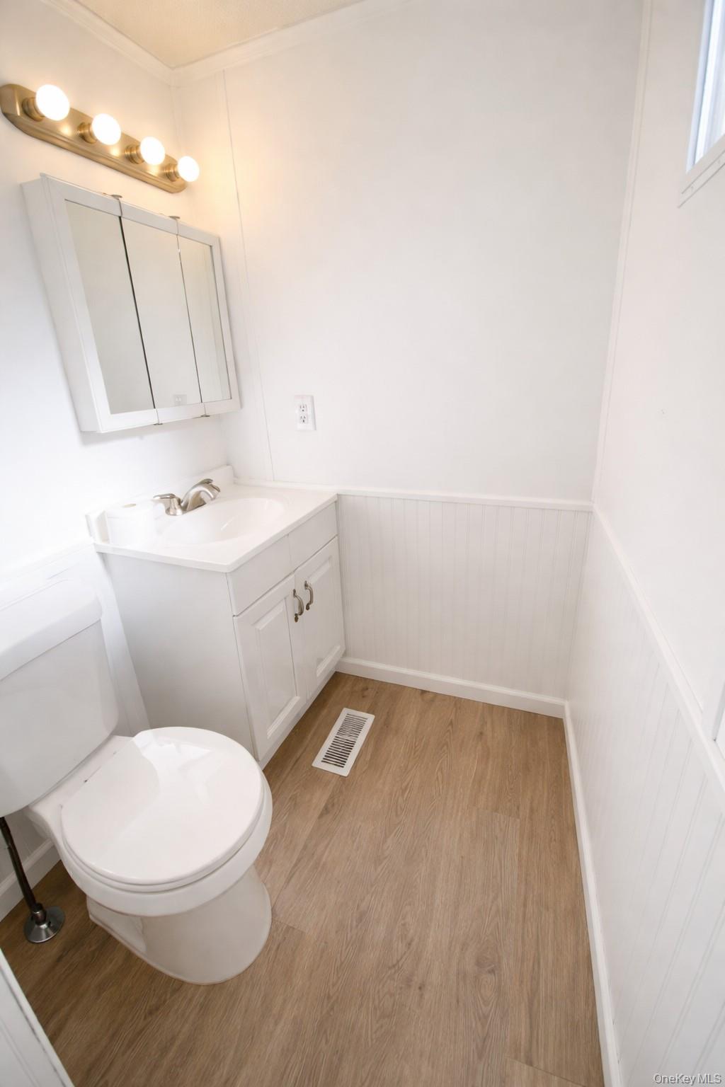 1661 Old Country Road, Unit 398 Riverhead, NY 11901 - Photo 12 of 14 a bathroom with a sink a toilet and mirror