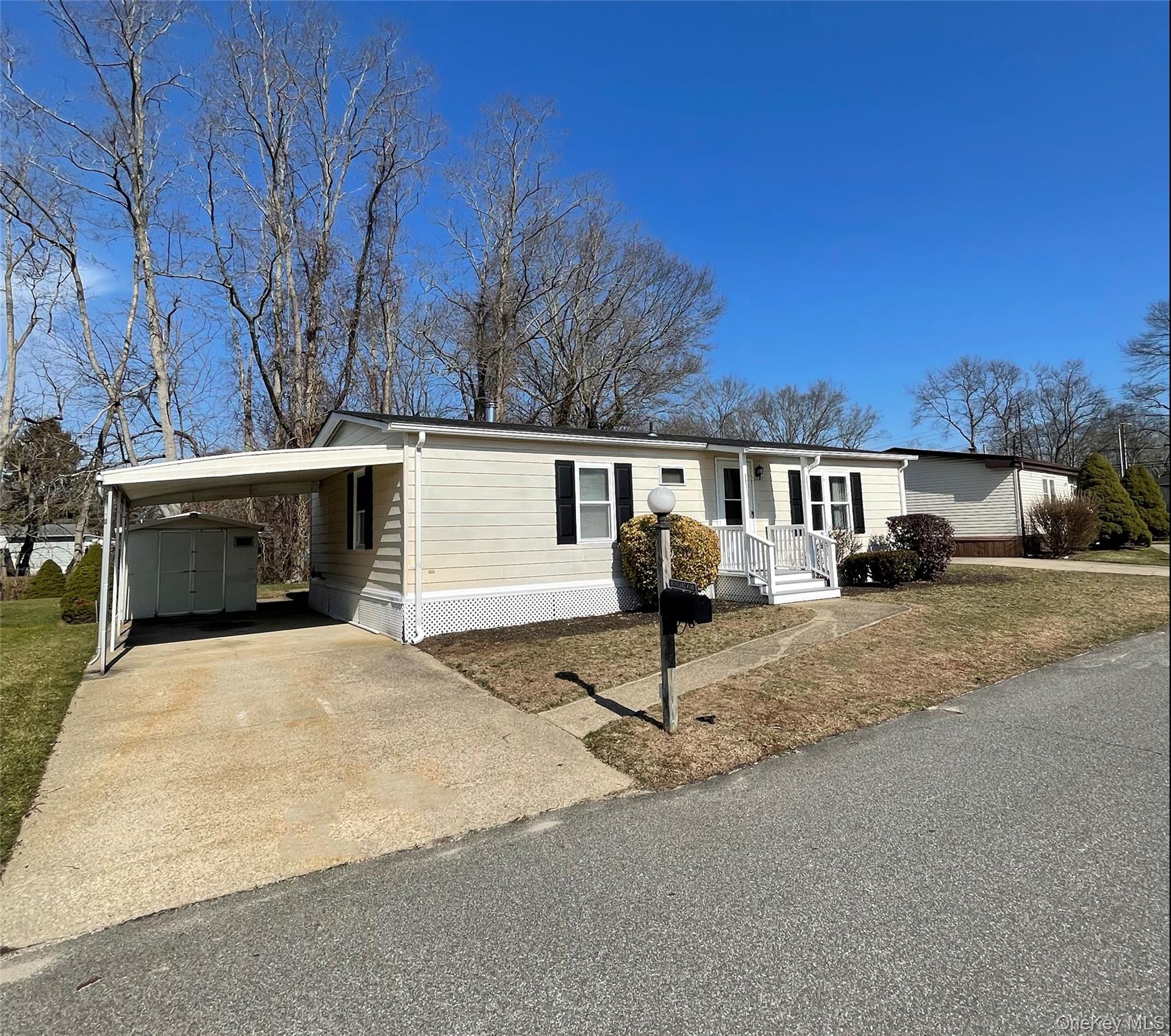 1661 Old Country Road, Unit 398 Riverhead, NY 11901 - Photo 3 of 14 a front view of a house with a yard and garage
