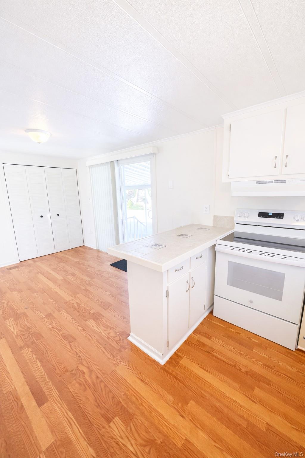 1661 Old Country Road, Unit 398 Riverhead, NY 11901 - Photo 6 of 14 a view of a kitchen with wooden floor and electronic appliances