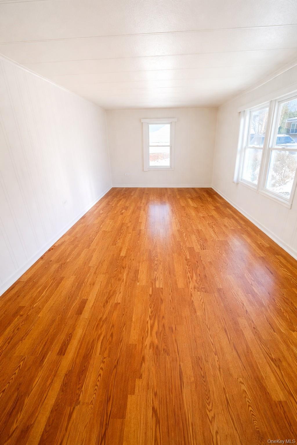 1661 Old Country Road, Unit 398 Riverhead, NY 11901 - Photo 8 of 14 an empty room with wooden floor and windows