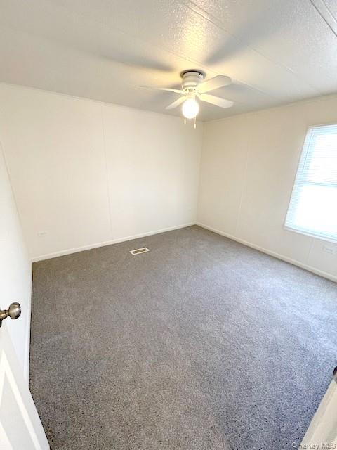 1661 Old Country Road, Unit 398 Riverhead, NY 11901 - Photo 10 of 14 an empty room with a window and chandelier fan