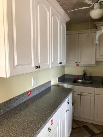 a kitchen with granite countertop a sink and cabinets