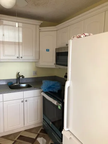a kitchen with white cabinets and sink