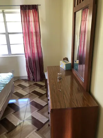 a living room with couches a fireplace and kitchen view with wooden floor