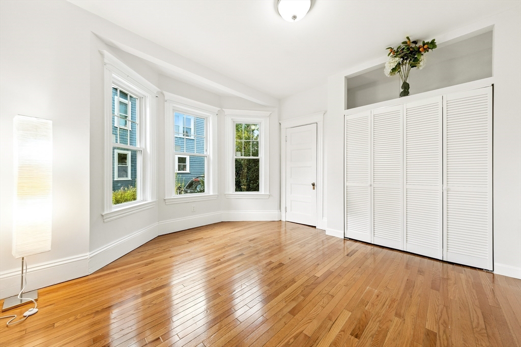 48 Harvard Street, Unit 1 Newton, MA 02460 - Photo 19 of 32 a view of an empty room with wooden floor and a window