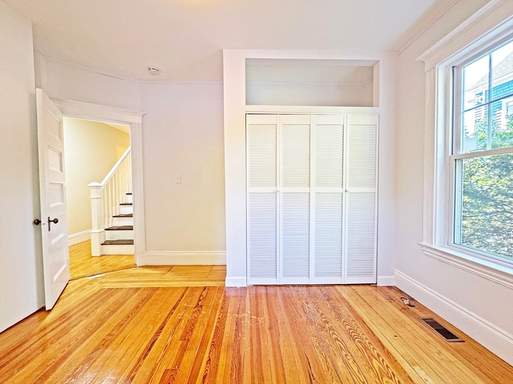 48 Harvard Street, Unit 1 Newton, MA 02460 - Photo 20 of 32 an empty room with wooden floor and windows