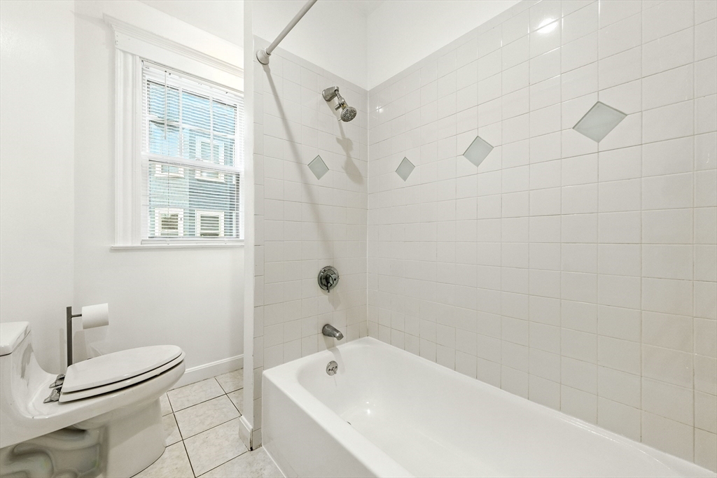 48 Harvard Street, Unit 1 Newton, MA 02460 - Photo 22 of 32 a bathroom with a bathtub and a shower