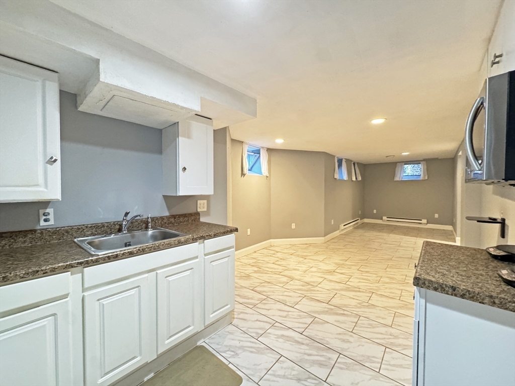 48 Harvard Street, Unit 1 Newton, MA 02460 - Photo 23 of 32 a bathroom with a granite countertop sink and a mirror