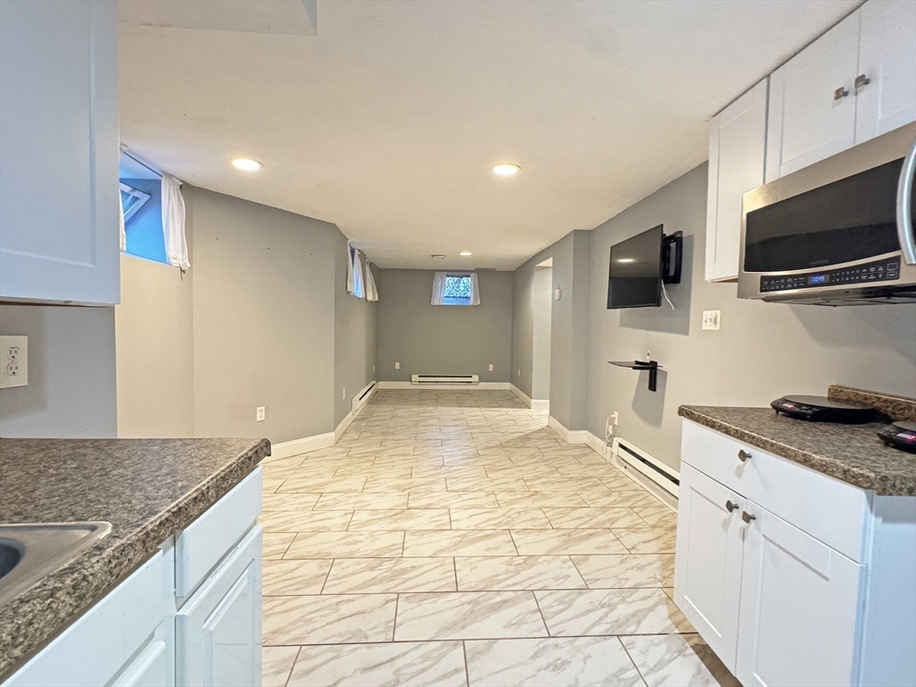 48 Harvard Street, Unit 1 Newton, MA 02460 - Photo 24 of 32 a kitchen with granite countertop a sink and a stove top oven
