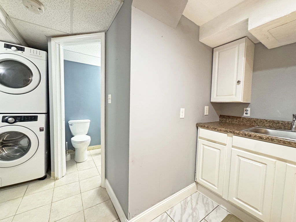 48 Harvard Street, Unit 1 Newton, MA 02460 - Photo 27 of 32 a view of a bathroom with washing machine and a sink