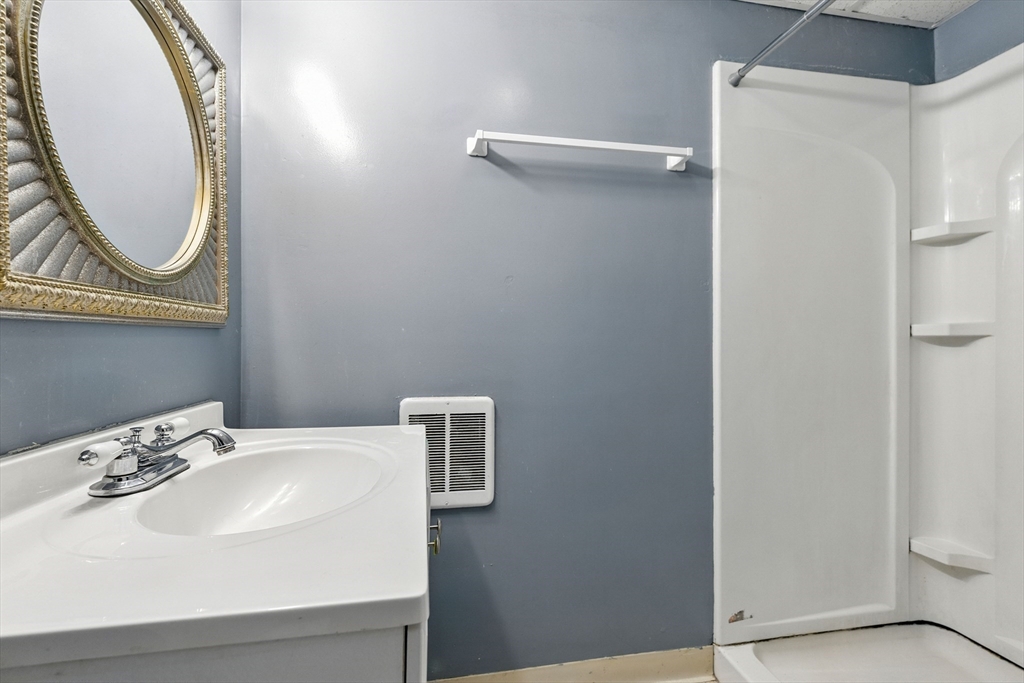 48 Harvard Street, Unit 1 Newton, MA 02460 - Photo 28 of 32 a bathroom with a sink and a mirror