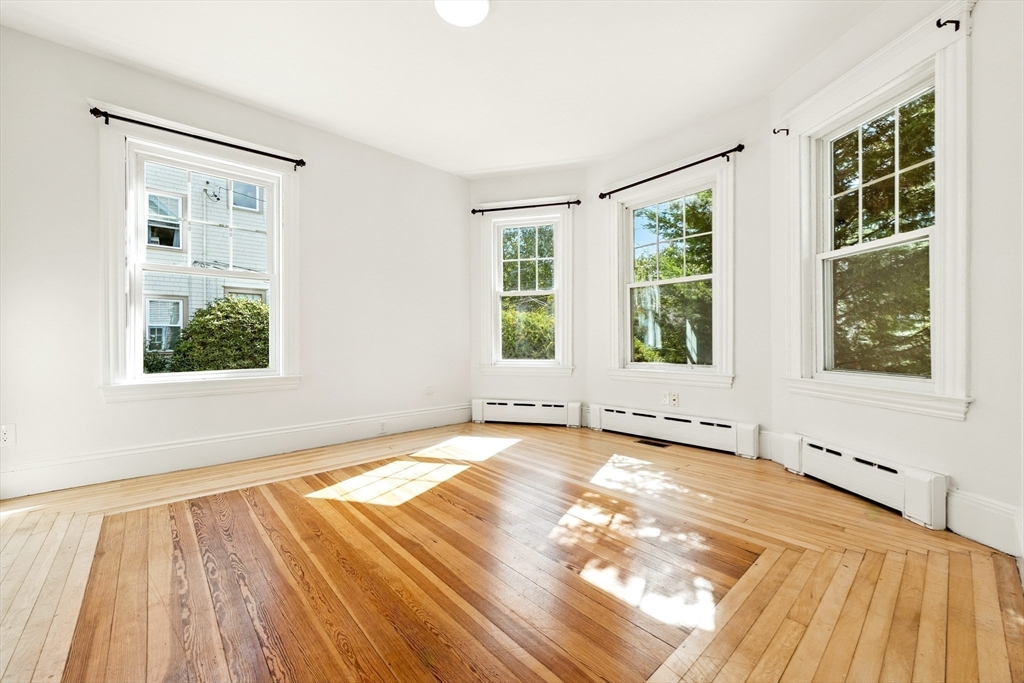 48 Harvard Street, Unit 1 Newton, MA 02460 - Photo 9 of 32 a view of an empty room with wooden floor and a window