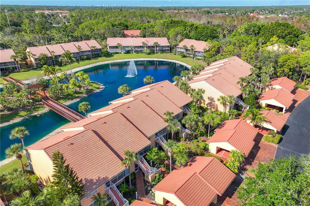 1625 Windy Pines Drive, Unit 5 Naples, FL 34112 - Photo 14 of 43 an aerial view of a house with a garden and lake view