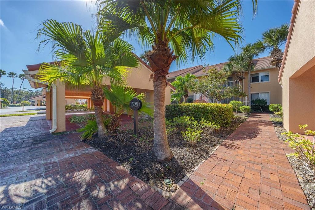 1625 Windy Pines Drive, Unit 5 Naples, FL 34112 - Photo 41 of 43 a view of a palm trees front of house with a small yard