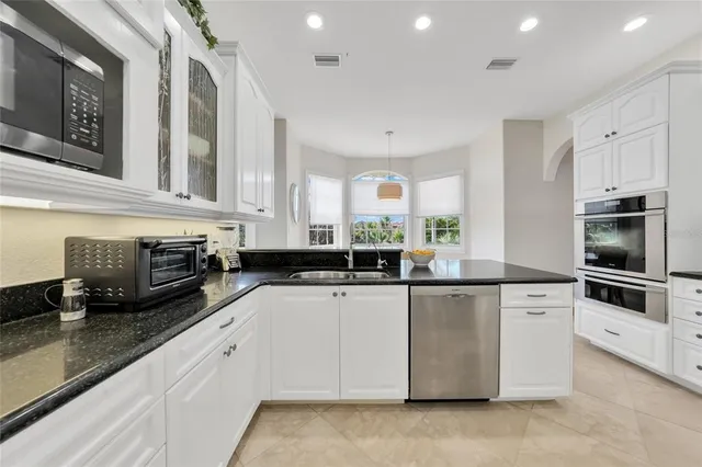 a kitchen with stainless steel appliances granite countertop a stove and a sink