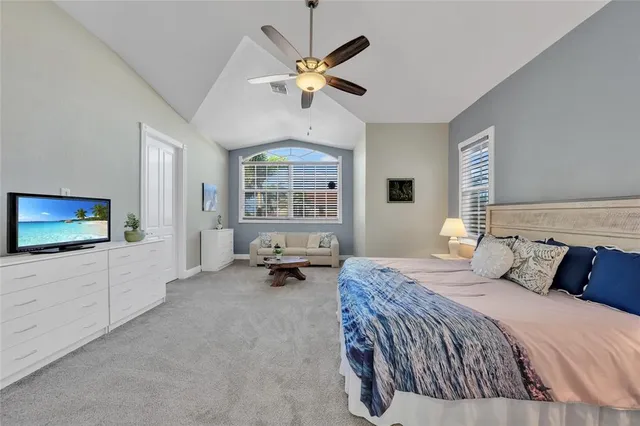 a bedroom with a large bed a flat screen tv and a window