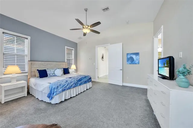 a bedroom with a bed mirror on dresser and a window