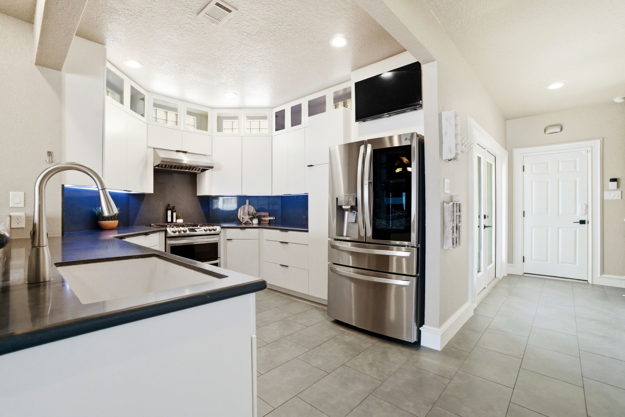 1609 Schooner Point Willis, TX 77318 - Photo 9 of 50 a kitchen with stainless steel appliances granite countertop a refrigerator a stove a sink and a microwave