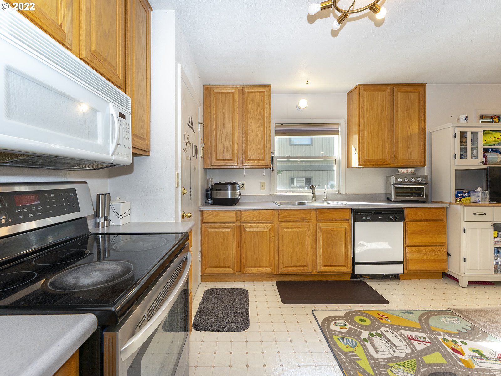 4530 Southwest 110th Avenue Beaverton, OR 97005 - Photo 16 of 32 a kitchen with a stove a sink and a microwave