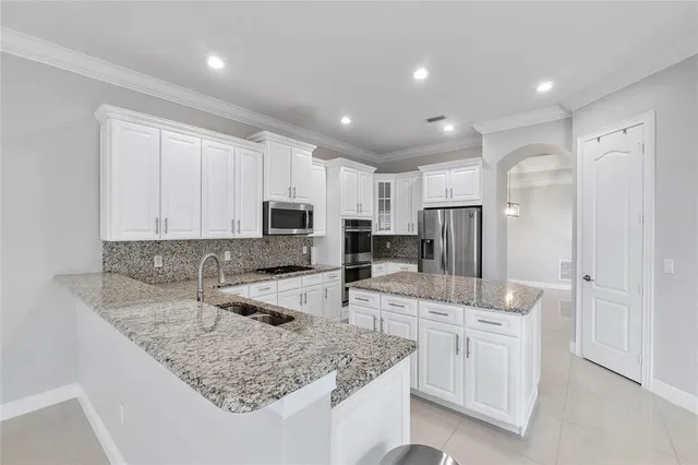 a kitchen with stainless steel appliances granite countertop a sink refrigerator and cabinets