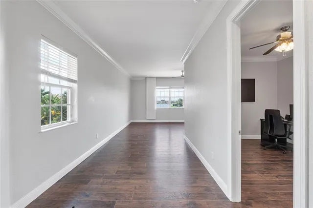 a view of a hallway with wooden floor and a living room