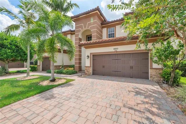 a front view of a house with garden and parking