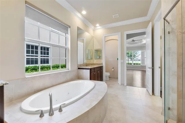 a spacious bathroom with a tub a sink and a large mirror