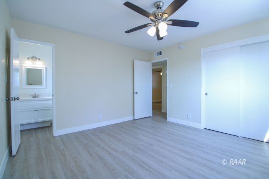 723 West Wilson Avenue Ridgecrest, CA 93555 - Photo 21 of 29 an empty room with wooden floor a ceiling fan and closet