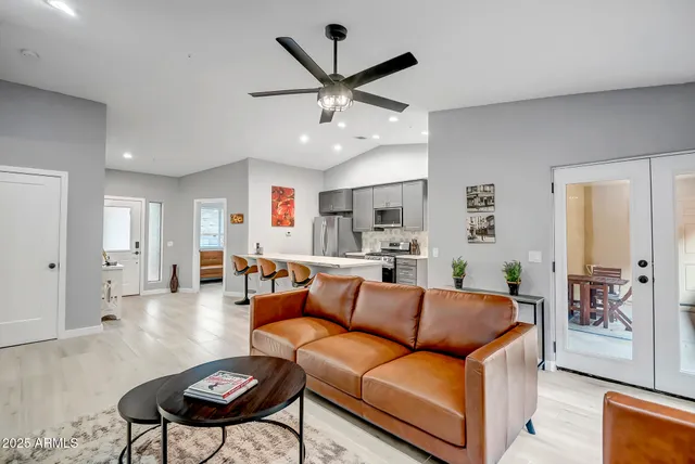 a living room with furniture kitchen view and a chandelier