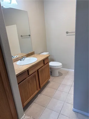 a bathroom with a granite countertop sink and a toilet