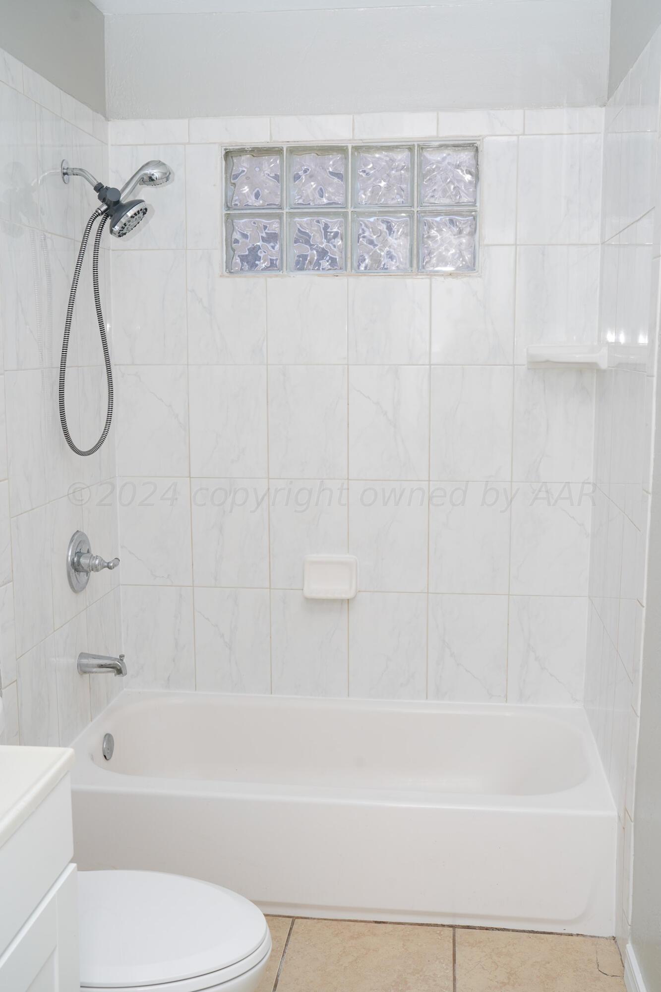 709 North Wells Street Pampa, TX 79065 - Photo 14 of 26 a bathroom with a toilet and a bath tub