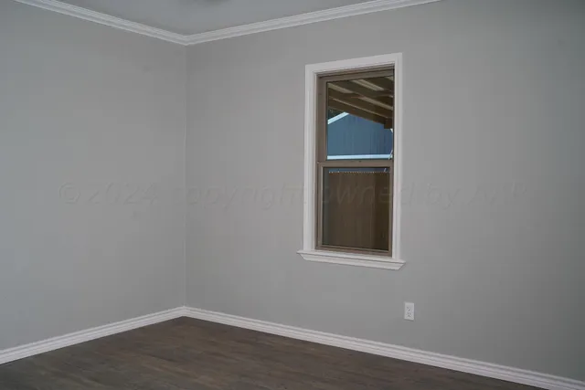 a view of an empty room with wooden floor and closet