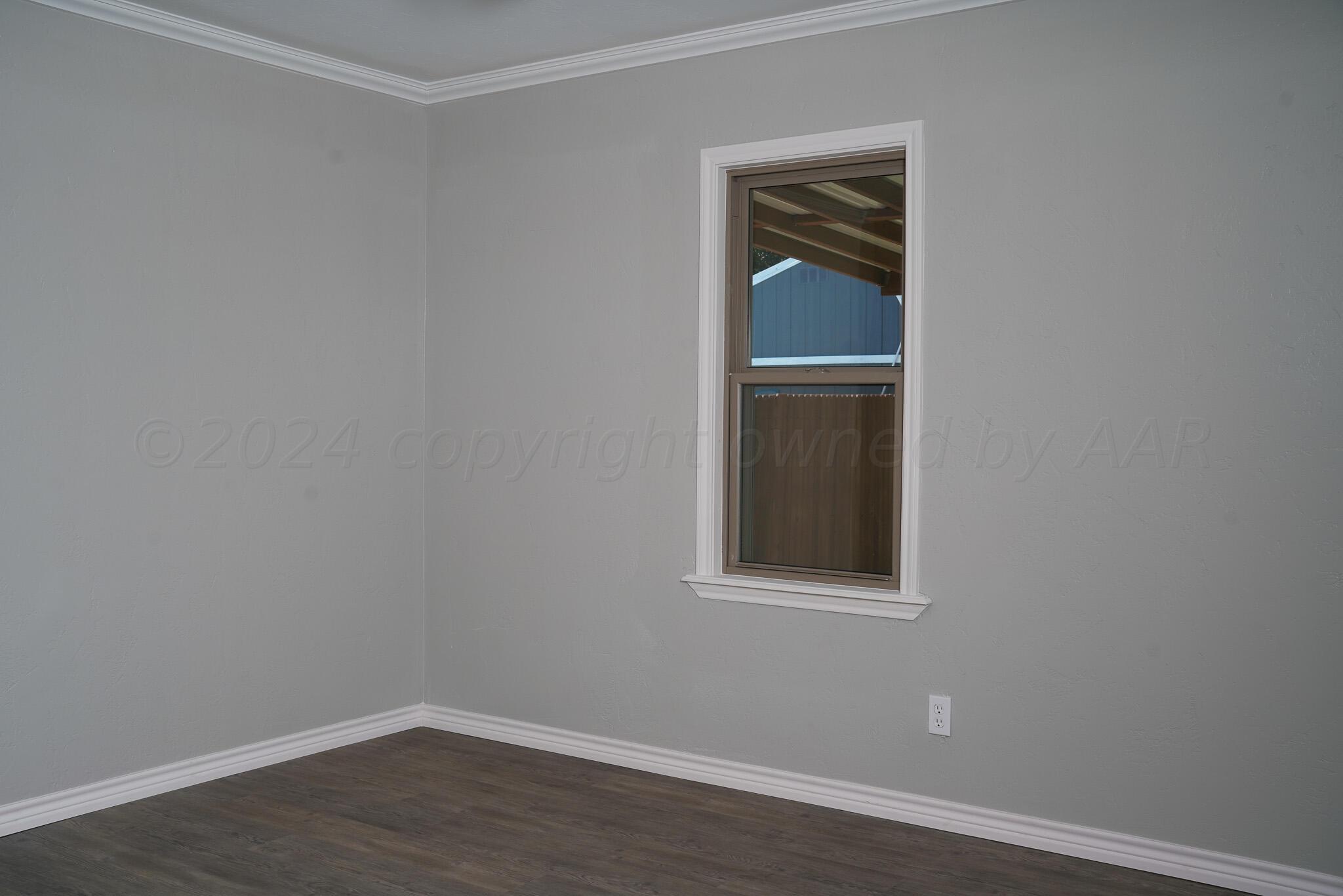 709 North Wells Street Pampa, TX 79065 - Photo 15 of 26 a view of an empty room with wooden floor and closet