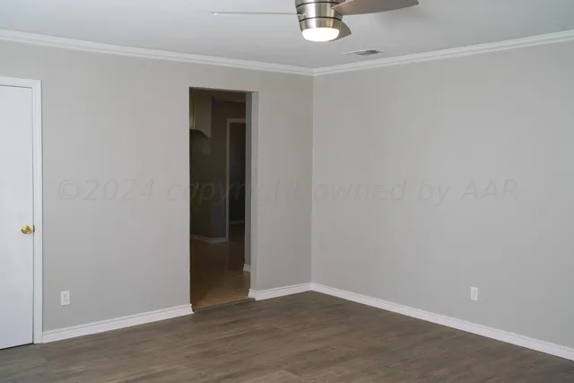 a view of an empty room with wooden floor
