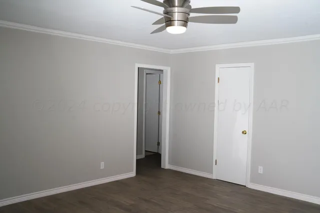 an empty room with wooden floor and hallway