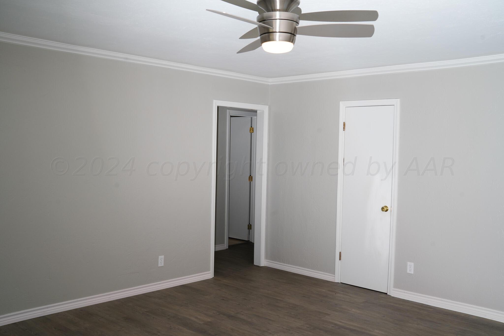 709 North Wells Street Pampa, TX 79065 - Photo 8 of 26 an empty room with wooden floor and hallway