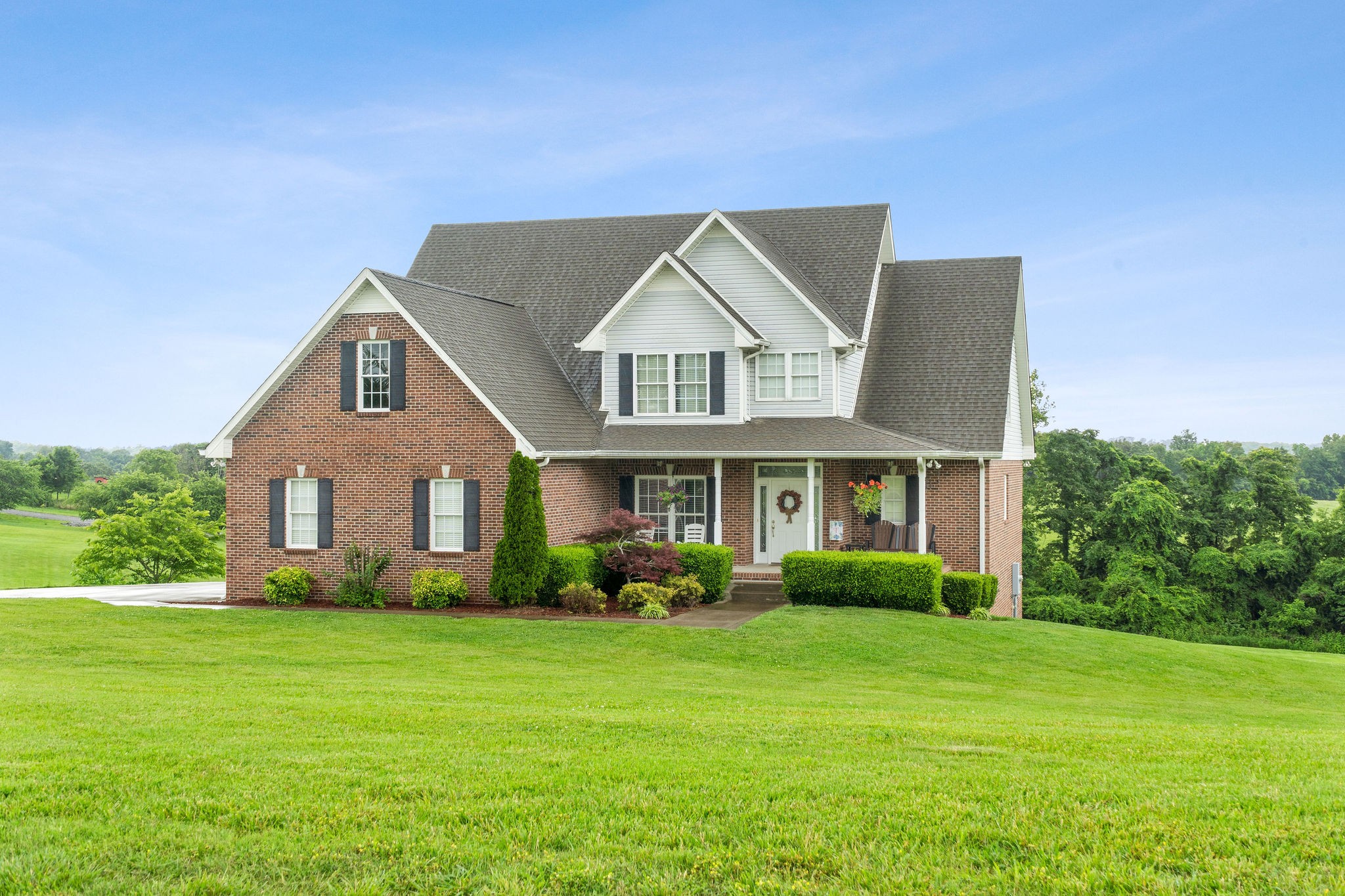 a front view of house with yard and green space